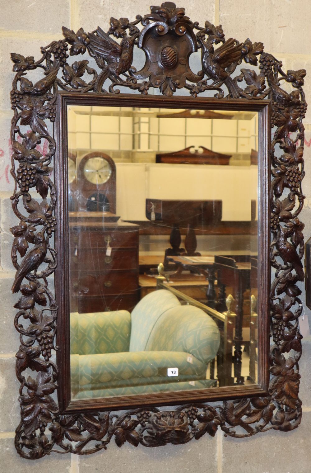 A 19th century Black Forest rectangular carved oak wall mirror decorated with birds amongst fruiting vines, W.90cm, H.130cm.